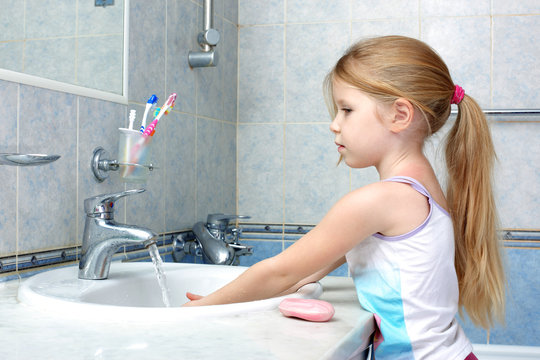 Little girl washing in bathroom