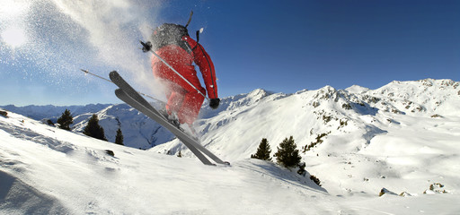 Skifahrer springt in Tiefschneehang