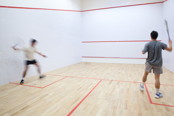Fototapeta na wymiar Squash players in action on a squash court (motion blurred image
