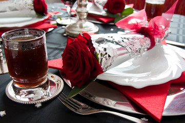 Festive table setting for Christmas with silver and red rose