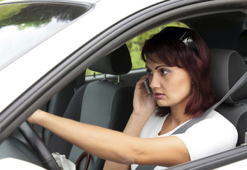 Fototapeta na wymiar Woman driver on phone while driving