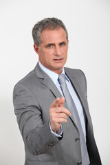 Businessman standing with finger pointed at camera