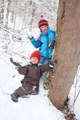 Kinder lauern hinterm Baum