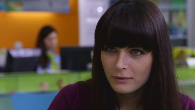 Красивая девушка говорит с менеджером и смотрит журнал