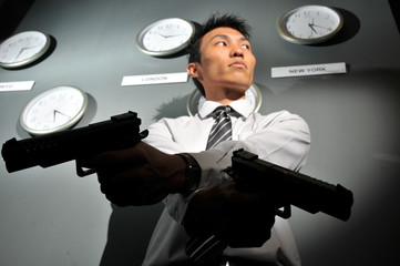 Asian Man with a Gun and clocks behind him