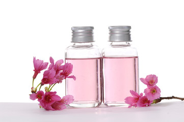 Obraz na płótnie Canvas Bottle of massaging oil and Pink cherry