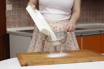Young woman sifting flour