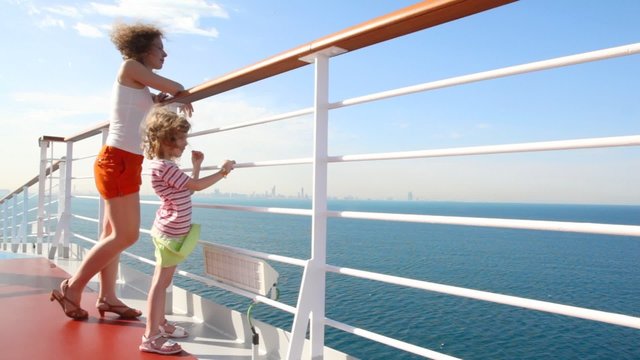 mother and daughter stands on deck of cruise ship