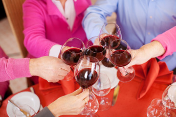 freunde stoßen mit rotwein an