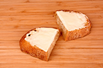 slice of bread buttered on a wooden stand