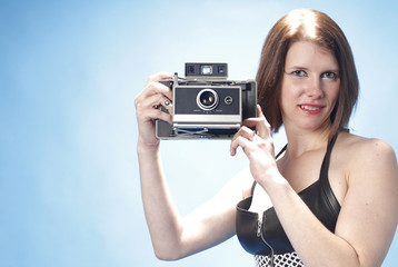 Sexy woman with an instant camera