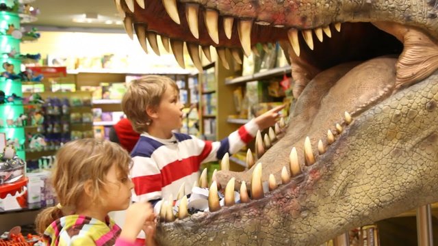 kids looks at mouth of toy dinosaur