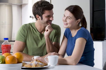 Obraz na płótnie Canvas couple having breakfast in the kitchen