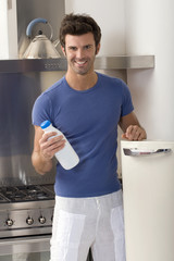 Fototapeta na wymiar man in the kitchen with a bottle of milk