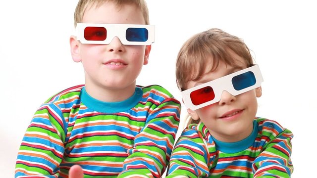 boy and girl sit in anaglyph glasses and applaud