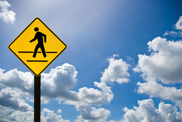 A man walking sign with cloudy sky