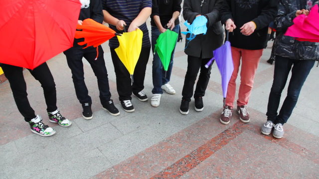 young men reveal umbrellas and twist them