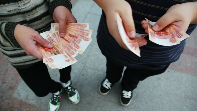 hands of two men believe Russian Ruble front of camera