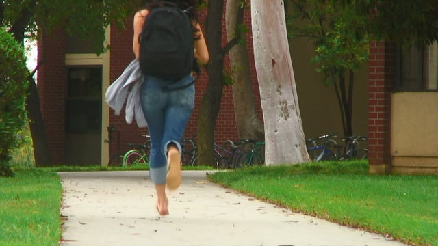 Young woman at school running to class