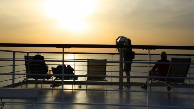 silhouettes of people on deck of cruise ship