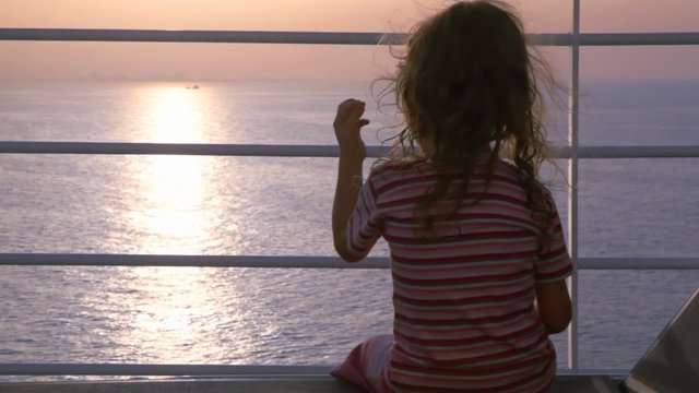girl sits on deck of cruise ship