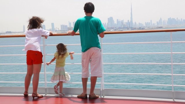 family is standing on deck of cruise ship