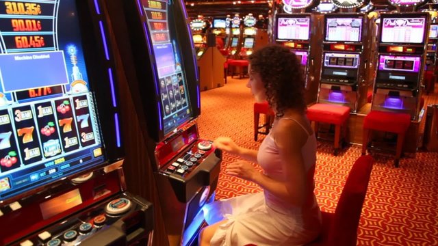 Woman at slot machine in play room in Persian Gulf.