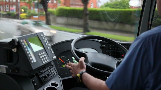 back view of man driving bus on  rainy road