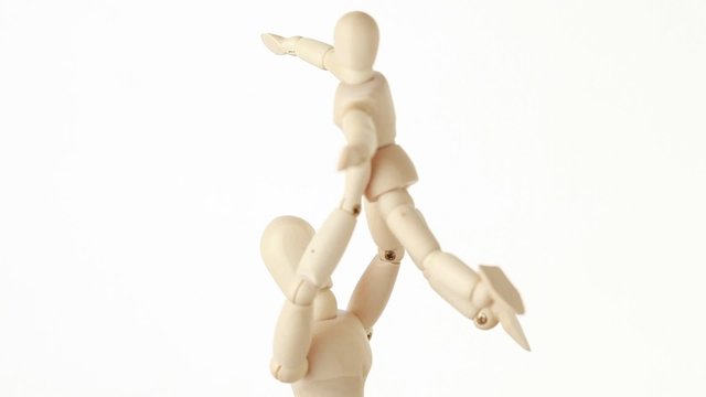 figures of parent carrying child over head, child aparting hands