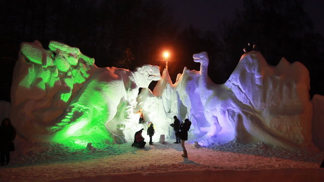 snow sculptures of dinosaurs at artificial illumination