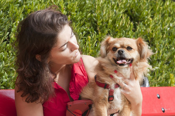 Girl with dog sitting on the park.