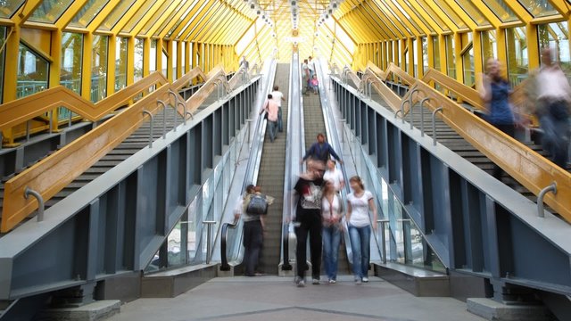 People rise and fall on the escalator in footbridge.