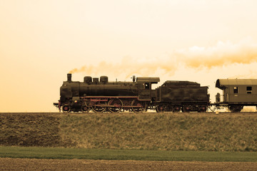 Old retro steam train passing through countryside