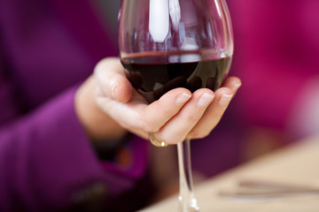 frau hält ein glas rotwein in der hand