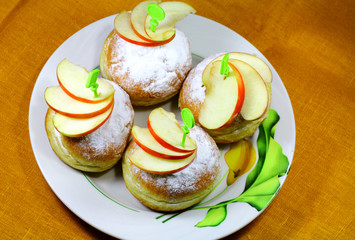 Tasty buns with pieces of apples on the plate