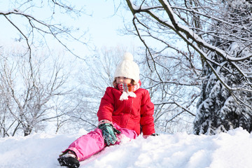 The girl sitting on snow in the park - obrazy, fototapety, plakaty