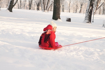 A small child riding on sledge in snow
