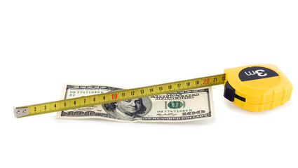 one hundred bill in US currency and tape measure