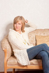 Obraz premium young woman sits on a sofa