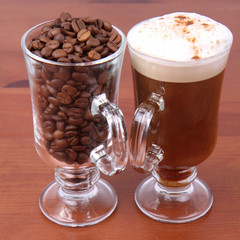Glass of caffe latte with a glass of coffee beans