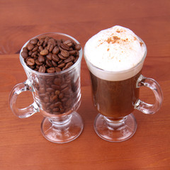 Glass of caffe latte with a glass of coffee beans