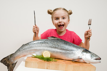 Little girl and big fresh fish - healthy eating seafood