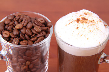 Glass of caffe latte with a glass of coffee beans