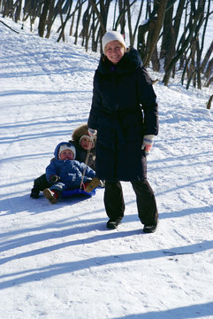 Mother and children in winter time with sled