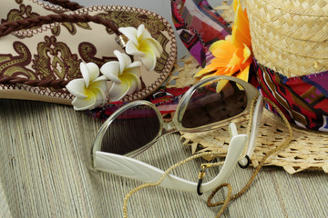 lunettes de soleil, chapeau de paille et tongs fleuris