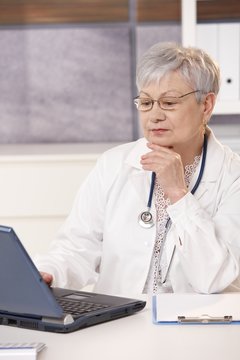 Senior doctor looking at computer