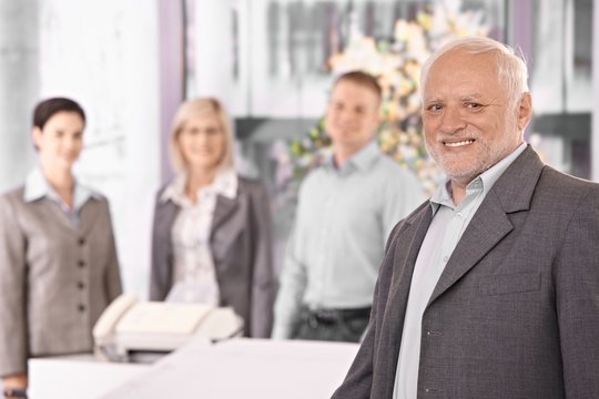 Portrait of senior executive businessman with team