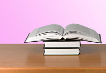 Open book on desk  on pink background