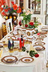 Luxuriant table appointments with red  china porcelain and rose