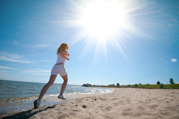 Fototapeta na wymiar Sport woman running in sea coast